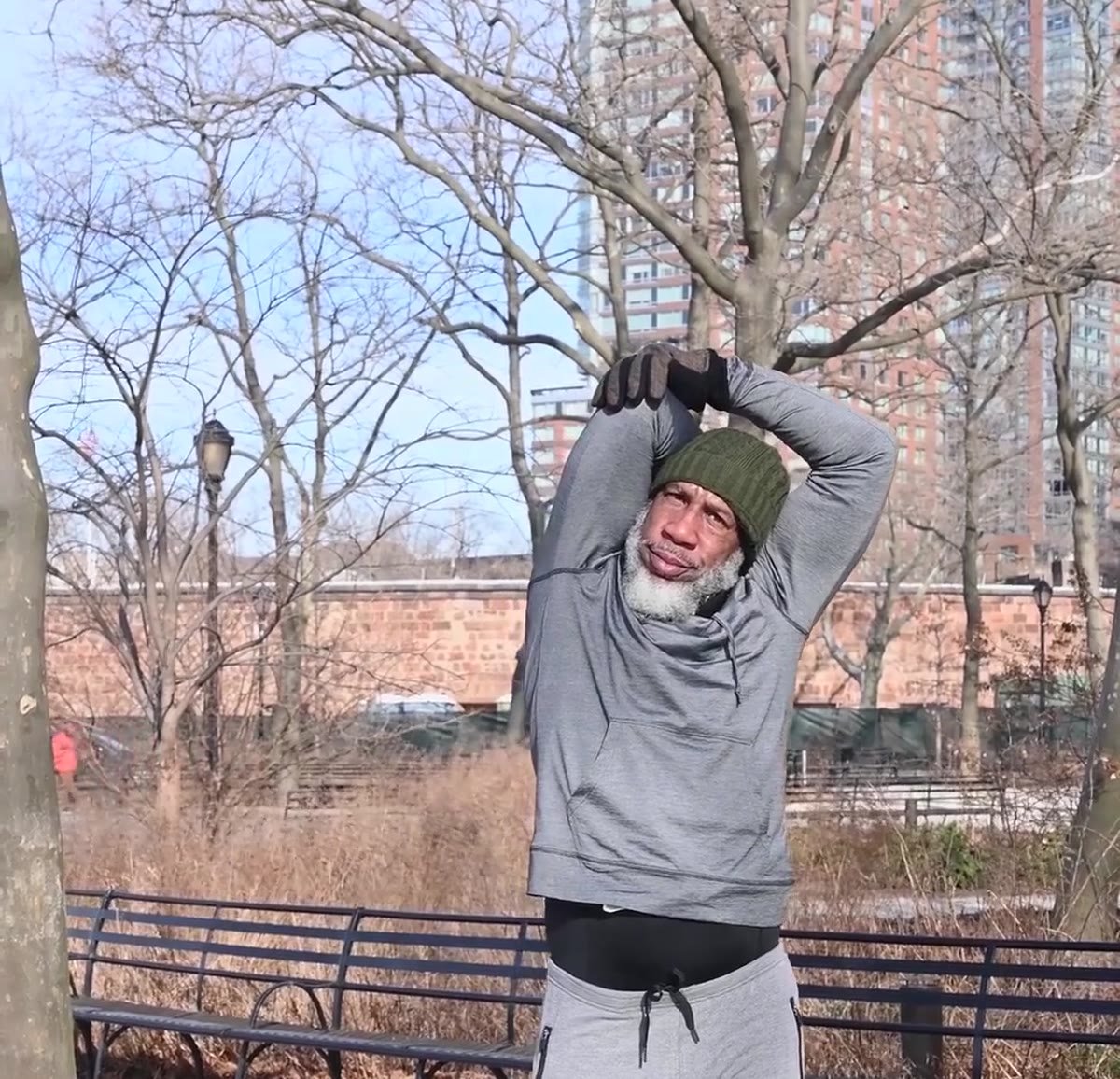 Man stretching outdoors in a park as part of a knee-friendly exercise routine